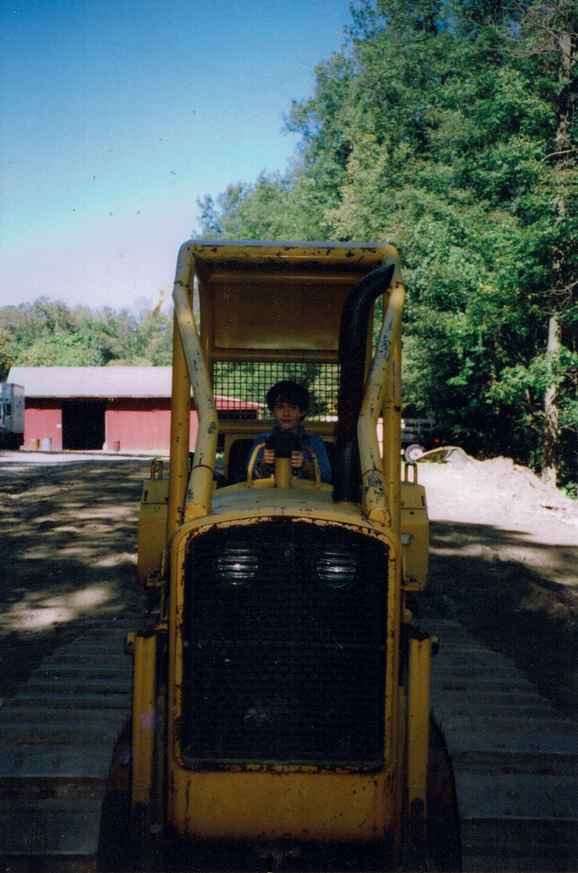 Beck Curtis at age six, sitting at the controls of a dozer at his grandparents' excavation yard